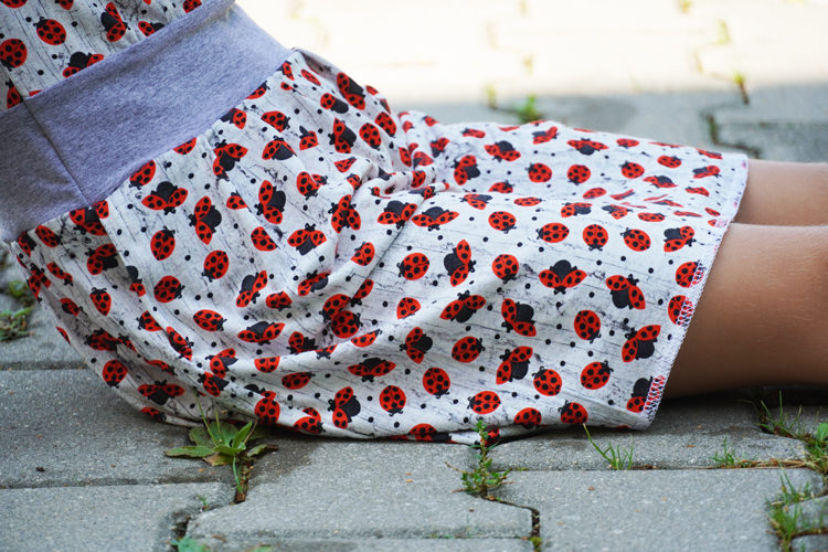 Střih na dětské šaty s dlouhým rukávem, kapsami a skládanou sukní